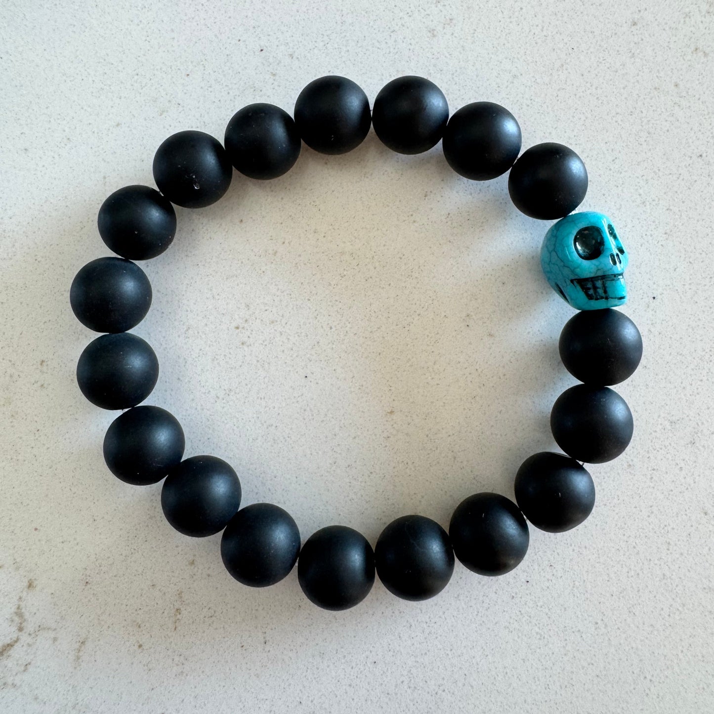 10mm Matte Black Onyx Gemstone Bead Stretch Bracelet with Blue Skull Accent Bead
