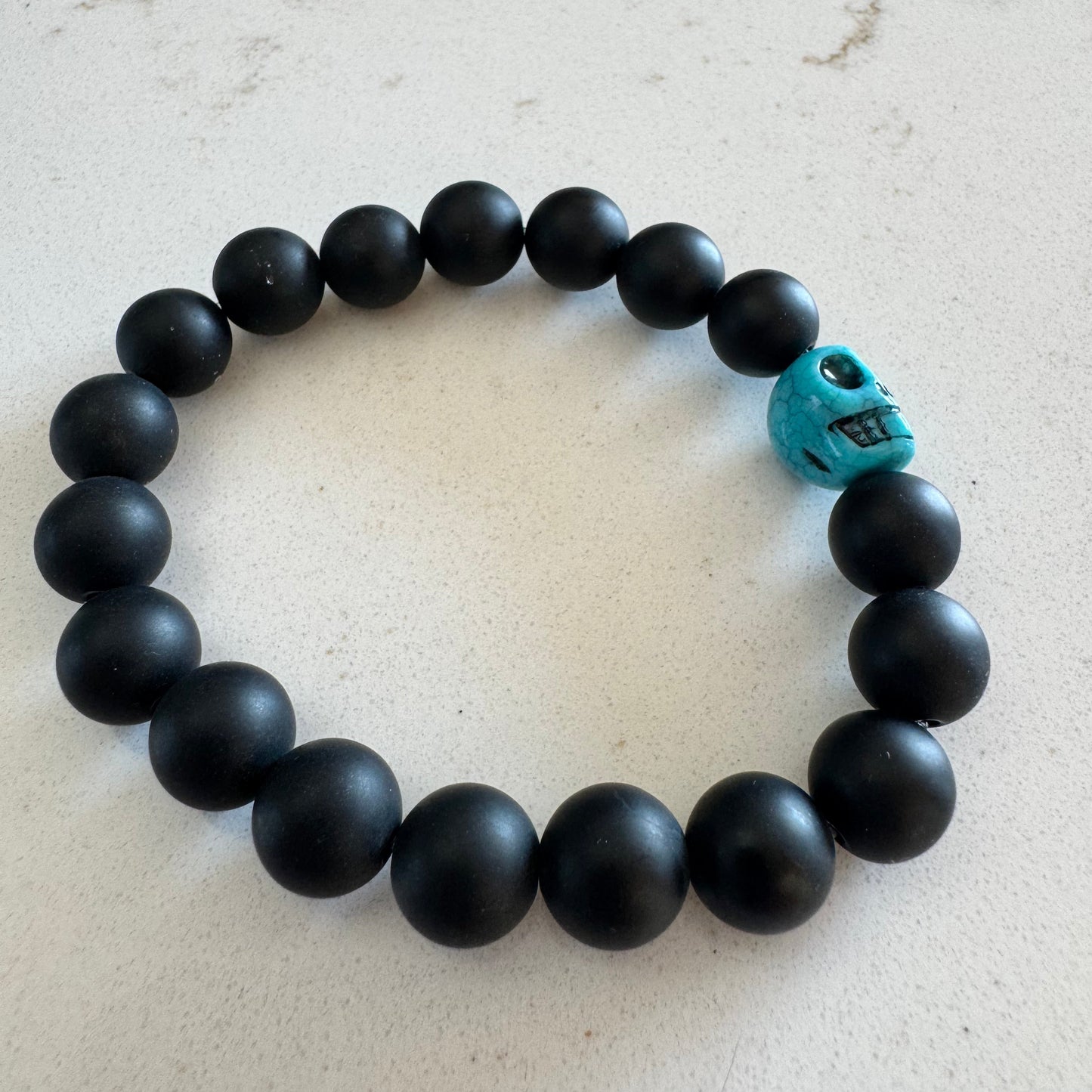 10mm Matte Black Onyx Gemstone Bead Stretch Bracelet with Blue Skull Accent Bead