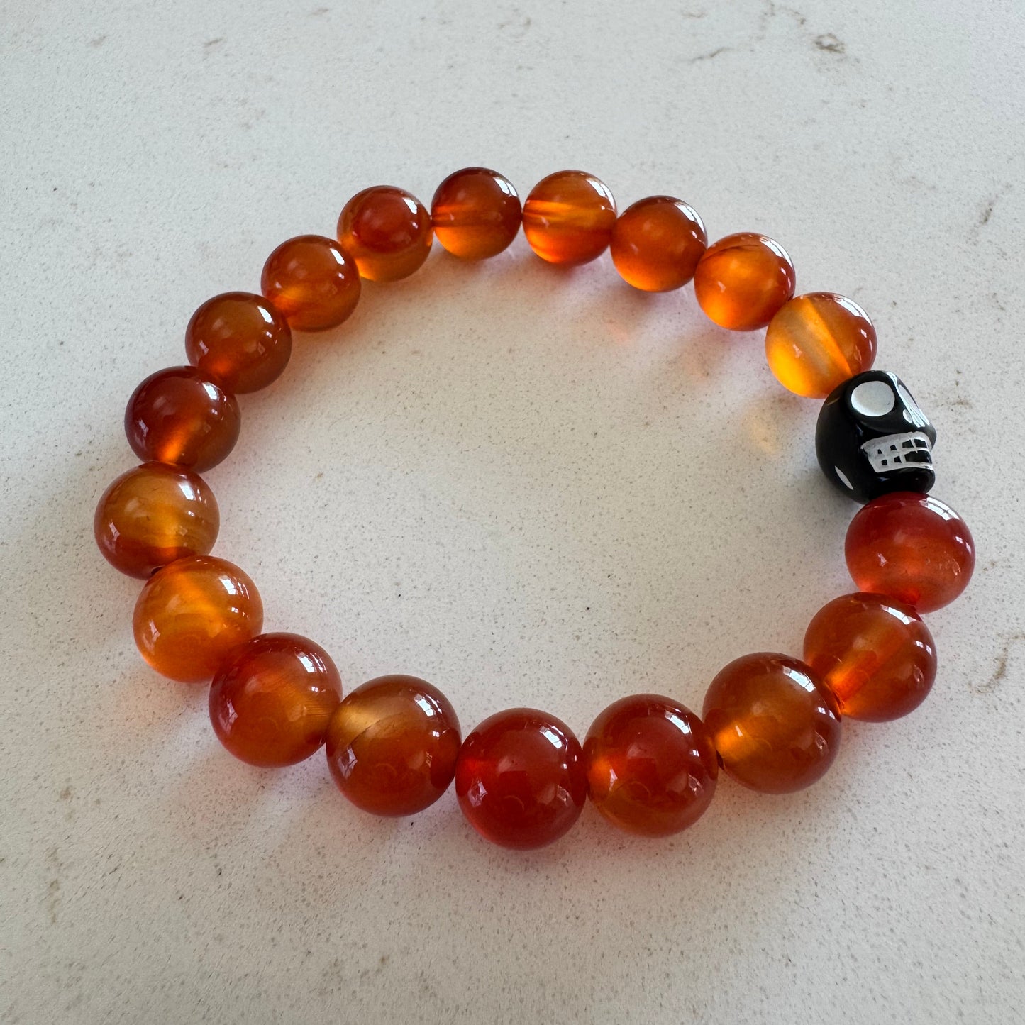 10mm Orange Carnelian Agate Gemstone Bead Stretch Bracelet With Black Skull Accent Bead